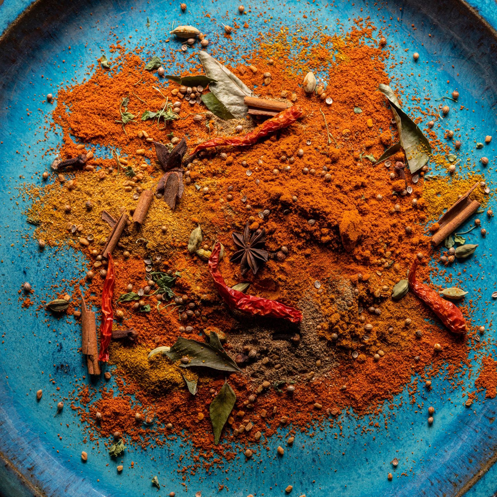 Assorted spices arranged on a plate for blending